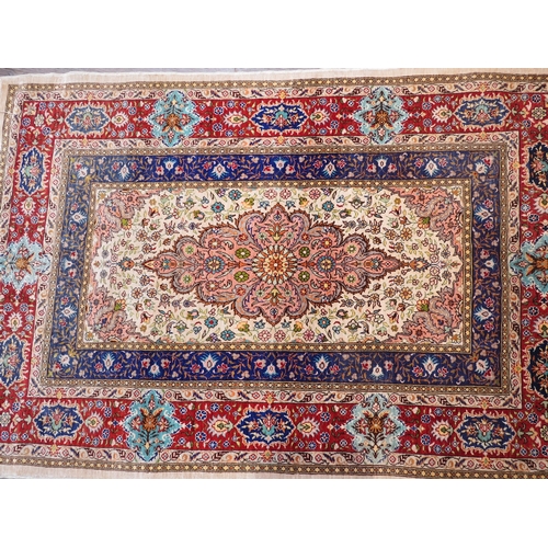 6057 - A 20th Century silk table rug with central floral medallion surrounded by multiple borders, tasselle... 