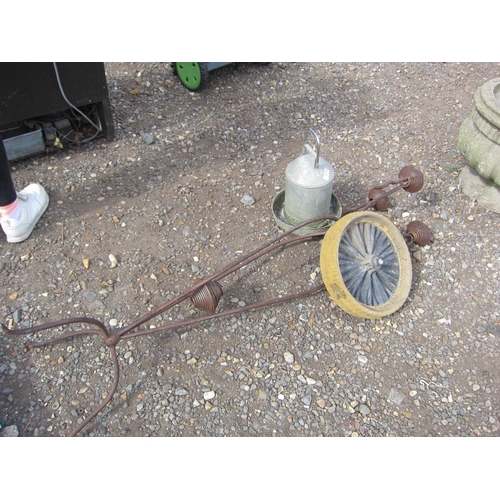 3318 - A metalwork candle stand, drinker and a implement wheel