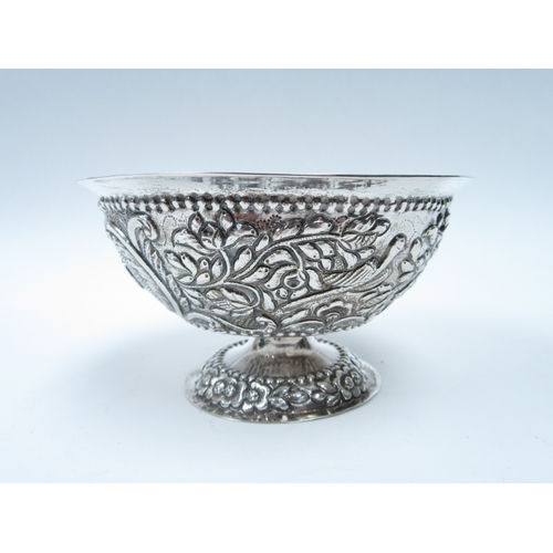 6415 - An Indian white metal pedestal bowl with repousse bird foliage and flower detail, 7cm tall, 13cm dia... 