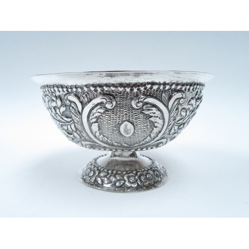 6415 - An Indian white metal pedestal bowl with repousse bird foliage and flower detail, 7cm tall, 13cm dia... 