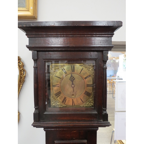 6062 - A late 18th Century oak long case clock, with brass square face and black roman numerals to the chap... 