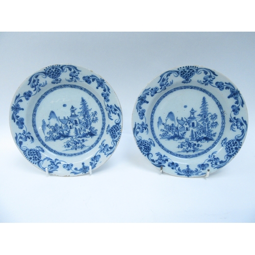 6010 - A pair of Oriental blue and white tin glazed plates with central image of dwelling and gardens and a... 