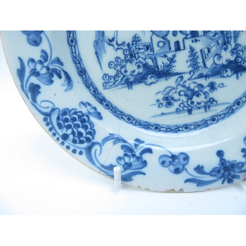 6010 - A pair of Oriental blue and white tin glazed plates with central image of dwelling and gardens and a... 