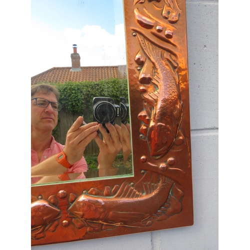 6002 - A Newlyn Arts & Crafts embossed copper mirror frame with fish and shell detail bevelled glass impres... 