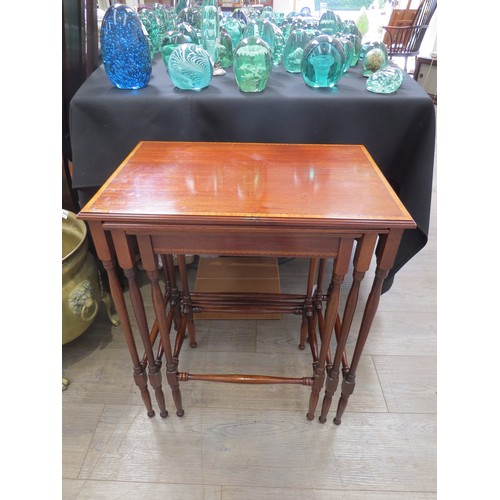 4282 - An Edwardian crossbanded inlaid mahogany nest of the three graduating occasional tables on turned le... 