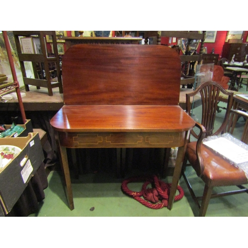 4004 - A late George III mahogany folding tea table with light wood stringing to the frieze, raised upon ta... 