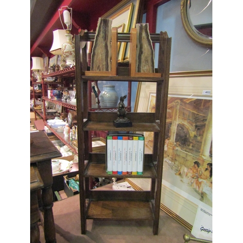 4017 - An early 20th century oak floor-standing four-tier bookcase of small proportions, with open sides an... 