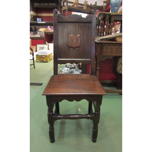 4023 - An 18th Century and later oak chair with armorial plaque, the flat seat over turned fore legs united... 