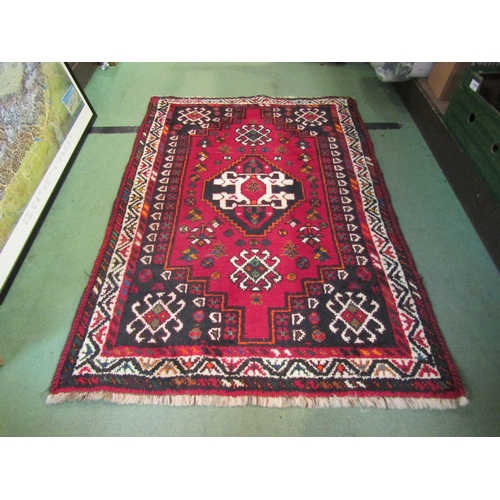 4242 - An Eastern wool rug, red ground, white geometric border, seven white motifs, 122cm x 84cm