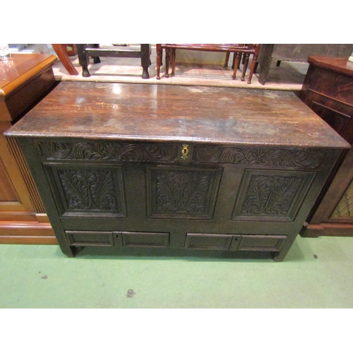 4259 - An early 18th Century oak triple panel mule chest, with leaf and flower carved frieze and facia over... 