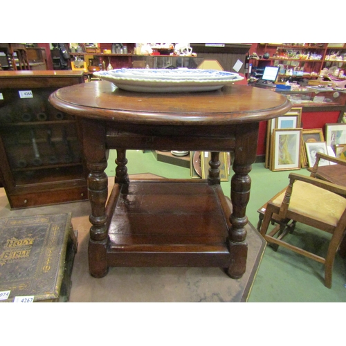 4264 - An 18th Century style country oak coffee table, circular top, turned supports over an under-tier, 48... 