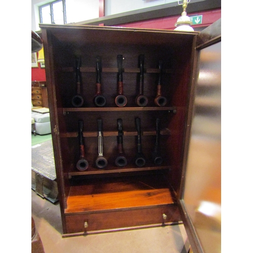 4266 - A mahogany pipe cabinet with ten pipes, mostly E.A. Carey.  Damage to beading, lower right edge