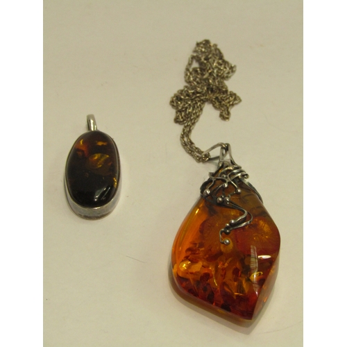 4438 - WITHDRAWN; A large amber pendant in silver mount hung on chain and an amber oval pendant in 925 moun... 