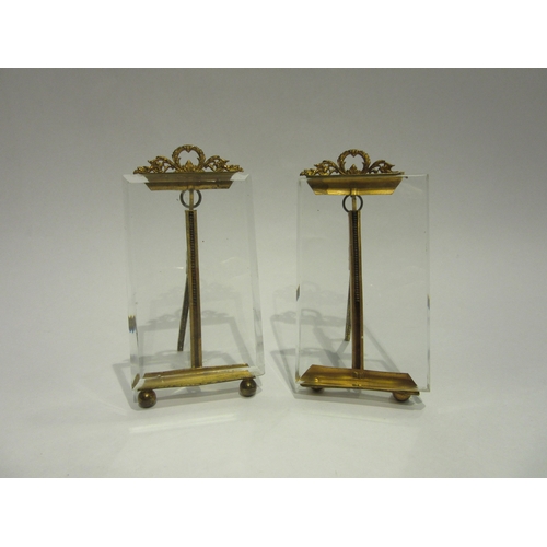 4390 - A small pair of Regency gilt easels with glass plaques, chip to one, each 12.5cm tall