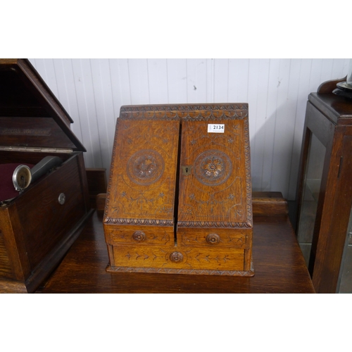 2134 - An Edwardian carved oak writing cabinet