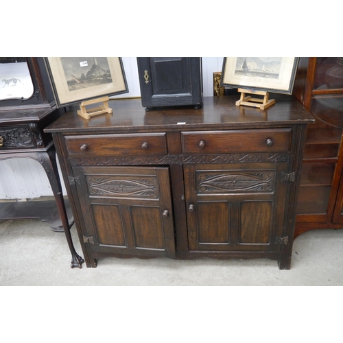 2165 - A carved oak two drawer, two door cupboard