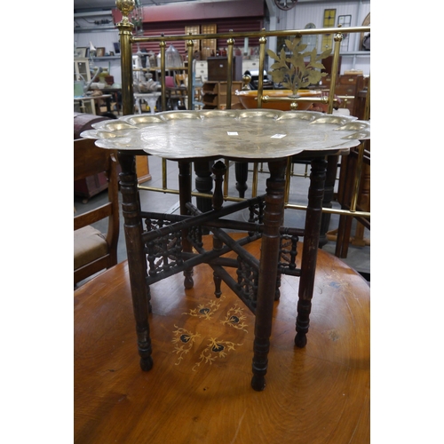 2287 - An Indian brass-top coffee table with folding hardwood base