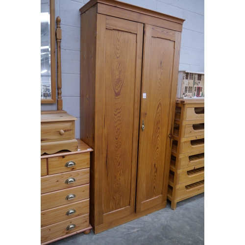 2353 - A tall stripped pitch pine two door linen cupboard, enclosing fixed shelves, 218cm tall