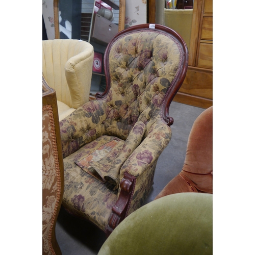 2406 - A 19th Century mahogany button back armchair with scrolled details and turned legs terminating on br... 