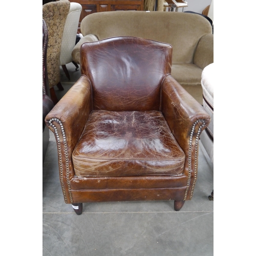 2412 - A worn leather armchair