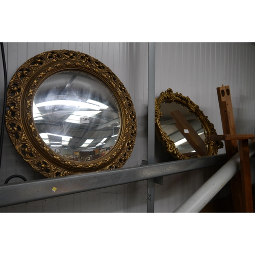 2489 - A circular convex gilt framed mirror and an oval gilt framed mirror