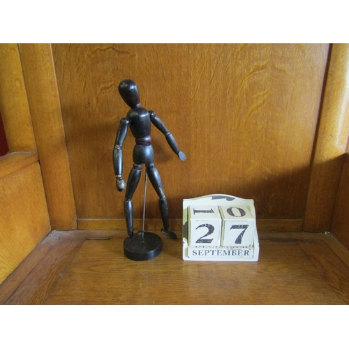 4090 - A wooden artist's articulated figure, 33cm tall, together with a wooden perpetual calendar (2)