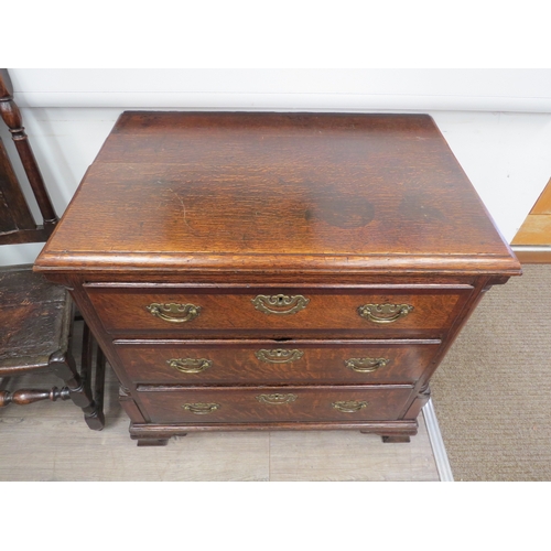 6029 - An early Georgian oak straight front chest of three long graduated drawers flanked by graduated draw... 