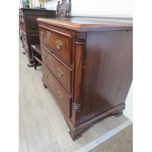 6029 - An early Georgian oak straight front chest of three long graduated drawers flanked by graduated draw... 