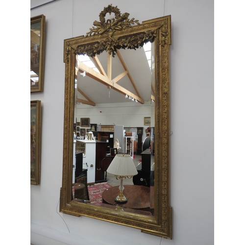 6101 - A classical gilt wooden framed pier mirror with floral garland embellishment, some areas of damage, ... 