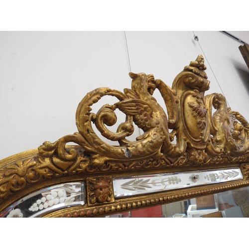 6074 - A late 19th Century highly ornate gilt and gesso pier mirror, the top surmounted by griffins, the bo... 