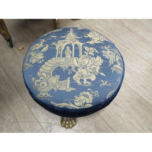 6005 - A 19th Century circular footstool with Chinese silk and velvet blue upholstery on ball in claw brass... 