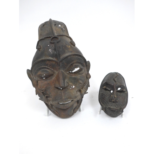 6318 - Two Nigerian cast metal masks with lizard detail. Holes present to both. 28cm and 12.5cm tall