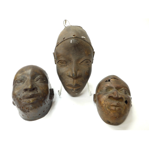 6300 - Three Benin bronze masks, one with holes. 13cm and 17.5cm tall