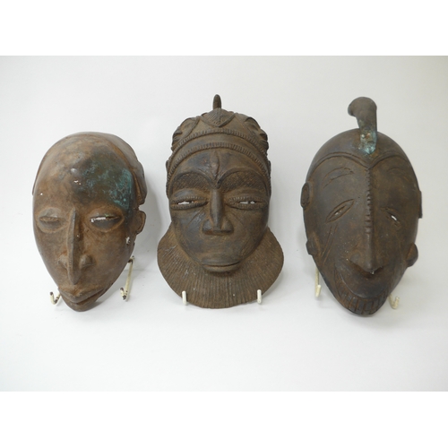 6298 - Three African cast masks including supernatural being. 27cm and 23cm tall