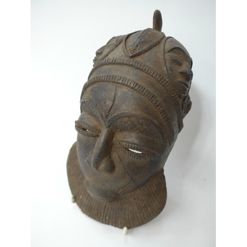 6298 - Three African cast masks including supernatural being. 27cm and 23cm tall