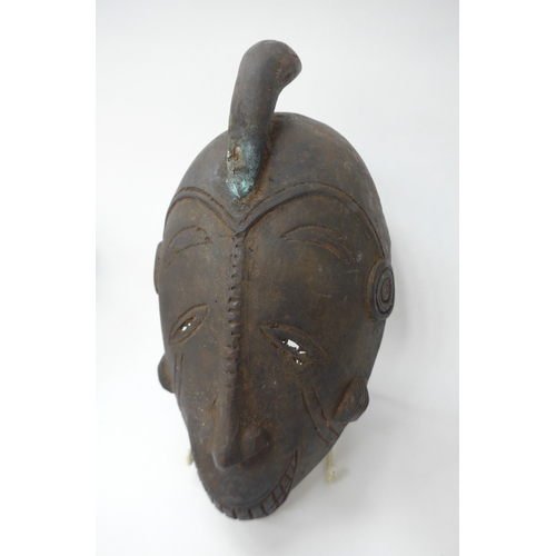 6298 - Three African cast masks including supernatural being. 27cm and 23cm tall