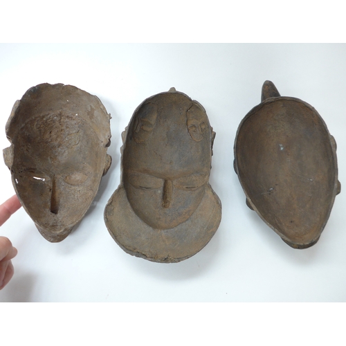 6298 - Three African cast masks including supernatural being. 27cm and 23cm tall