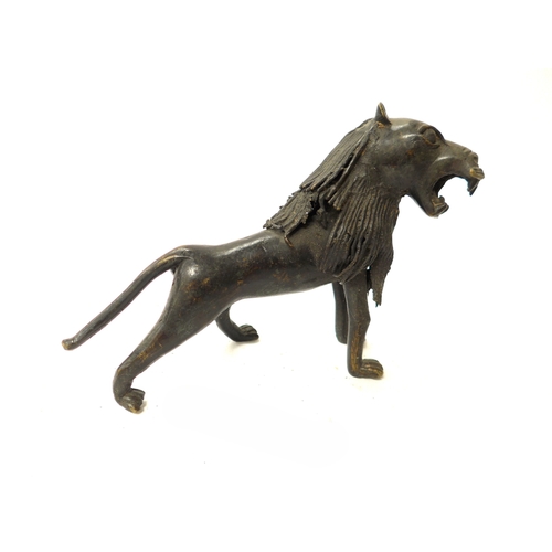 6302 - An African bronze statuette of a lion. 16.5cm tall x 25cm plus a bronze relief rider, Tada culture, ... 