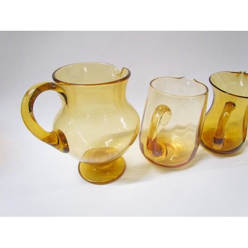 1314 - Four Amber glass jugs including Whitefriars.  Tallest 20cm