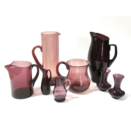 1318 - A collection of six amethyst coloured glass jugs including Whitefriars and a pair of amethyst vases.... 