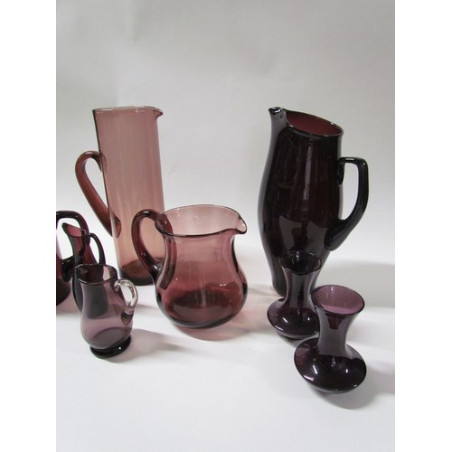 1318 - A collection of six amethyst coloured glass jugs including Whitefriars and a pair of amethyst vases.... 