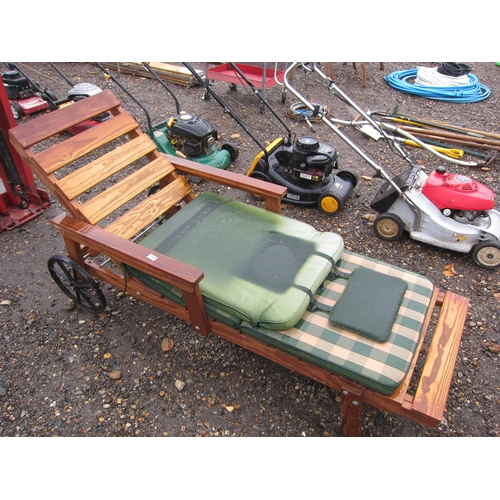 3424 - A teak garden lounger on wheels with covers