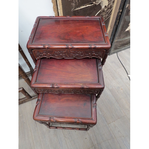 6016 - A nest of three Chinese padouk wood occasional tables with foliate decoration, largest 65cm x 45cm x... 