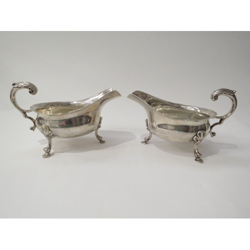 6445 - A pair of William Comyns & Sons silver sauce boats with scroll handles and hoof feet, London 1937, 1... 