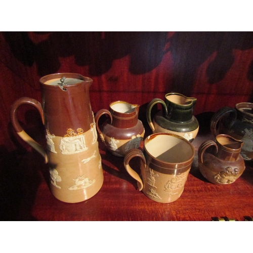 1007 - Five various Doulton Lambeth stoneware milk jugs, applied with taper motifs. A similar mug, teapot a... 