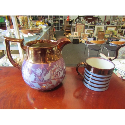 1010 - A large copper lustre jug decorated with an iridescent blue/purple band of flowers.  A copper lustre... 