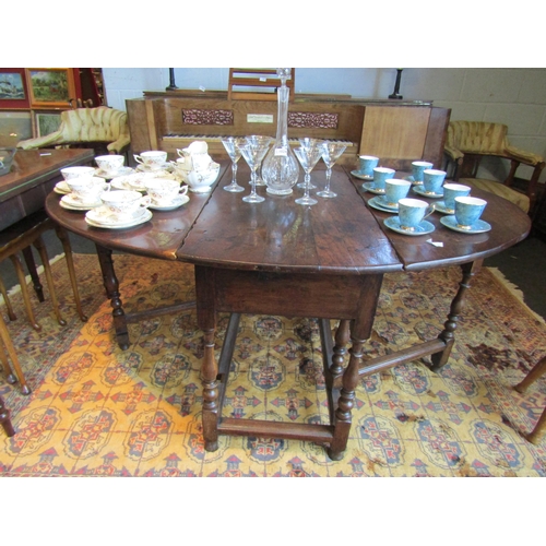 1026 - A 19th Century oak drop-leaf dining table on turned supports with stretcher base, 70cm tall x 150cm ... 