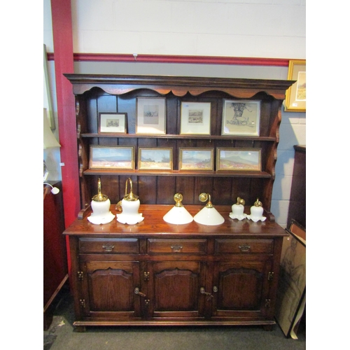 1087 - A 20th Century Georgian style oak dresser, plate rack back over three drawer, three cupboard door ba... 