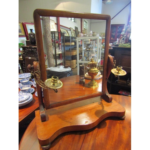 1096 - A Victorian dressing table mirror with brass swivel candle holders, serpentine base