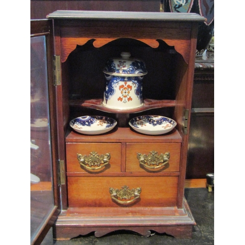 1117 - A smoker's cabinet with bevelled glass door and ceramic plates and dishes